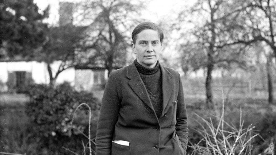Eve Balfour, black and white photo standing outside in front of farmhouse