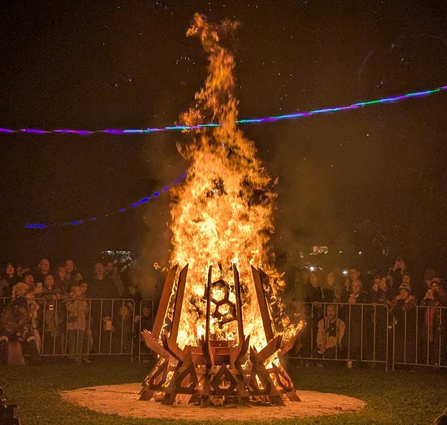 Solstice at CERES 2026, the large bonfire ablaze with surrounding crowd watching on